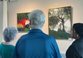 An artist speaks about her painting at a gallery