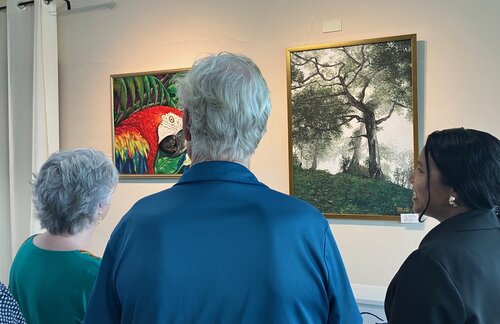 An artist speaks about her painting at a gallery